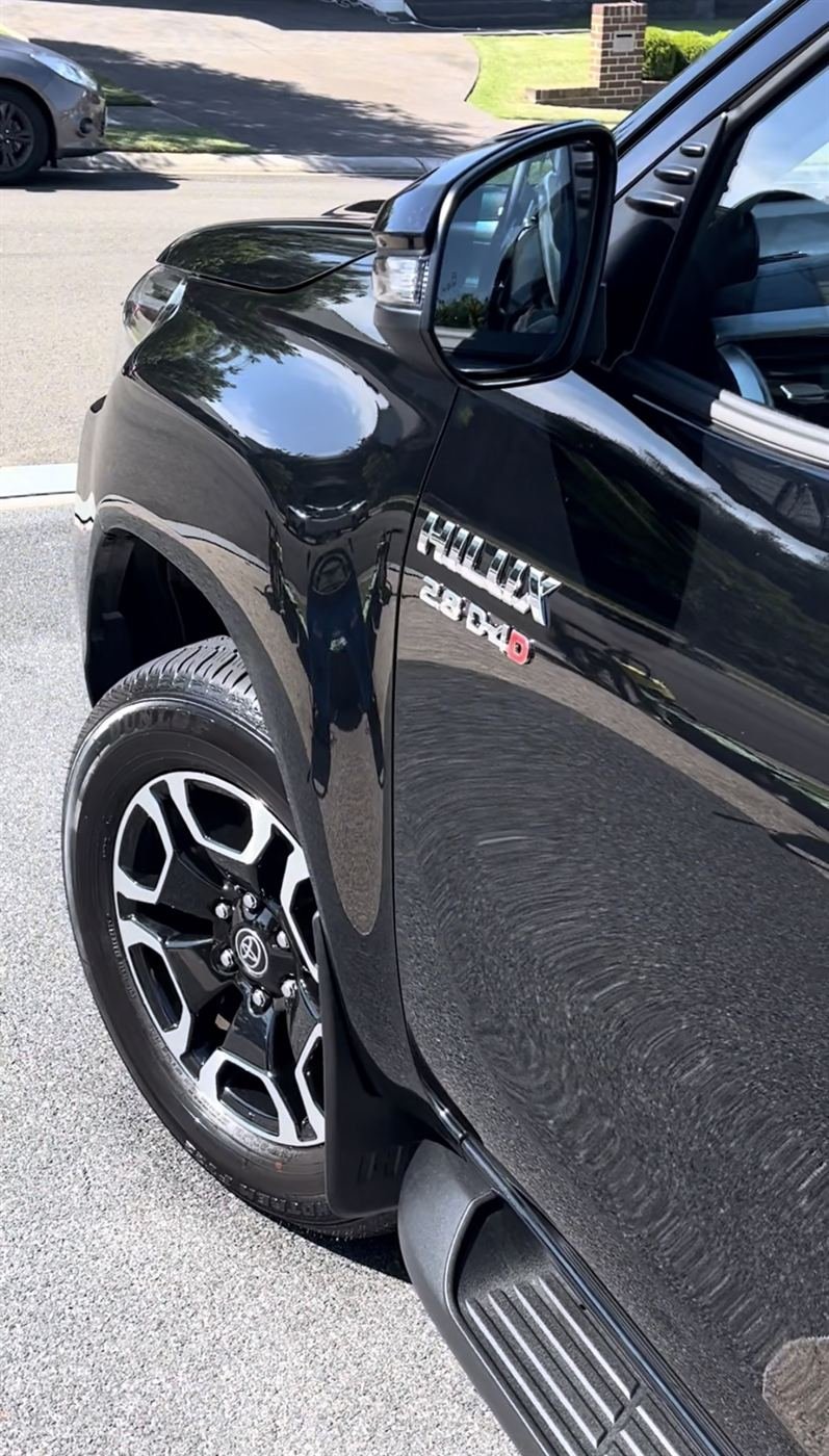 Black Toyota Hilux with glossy, reflective paint